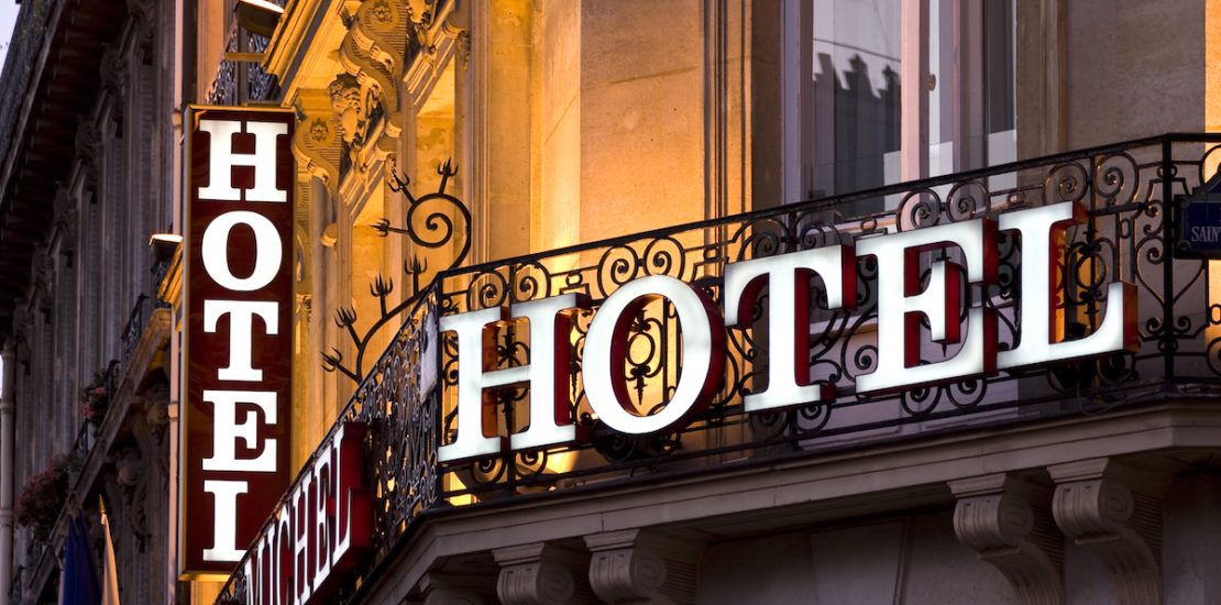 Illuminated Parisian hotel sign taken at dusk